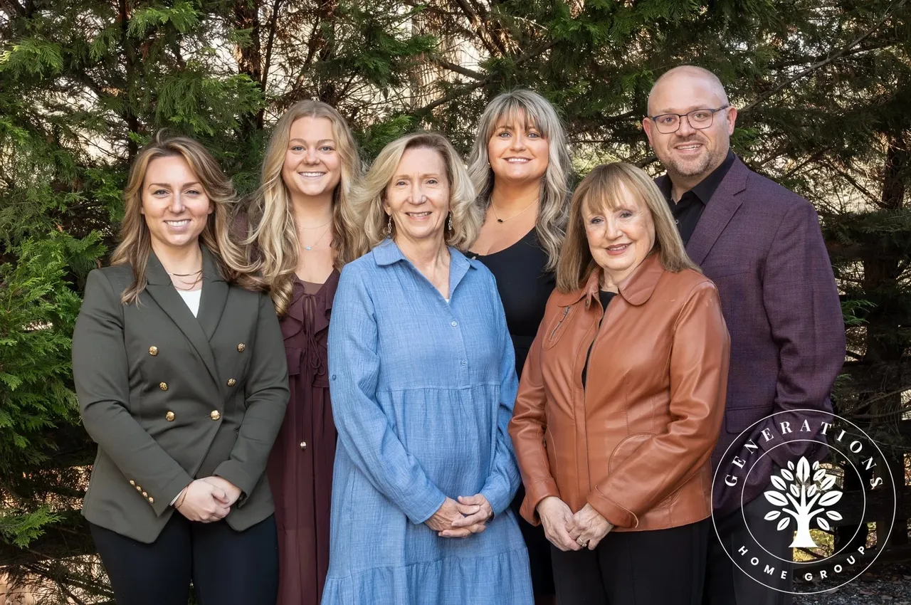 The six Realtors of the Generations Home Group, Noah Kaye among them, outdoors in front of evergreen trees