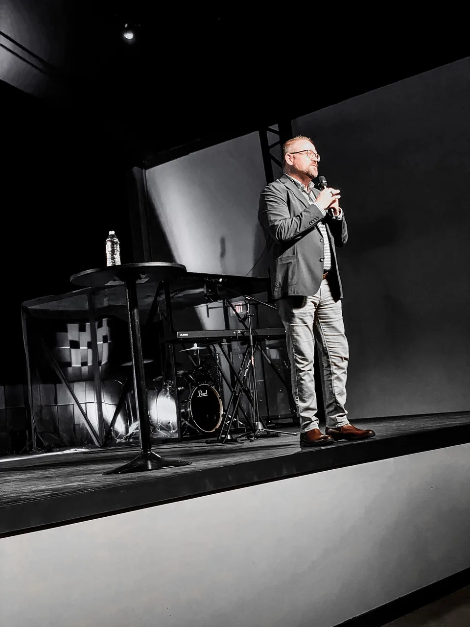 Noah Kaye speaking on stage with a microphone
